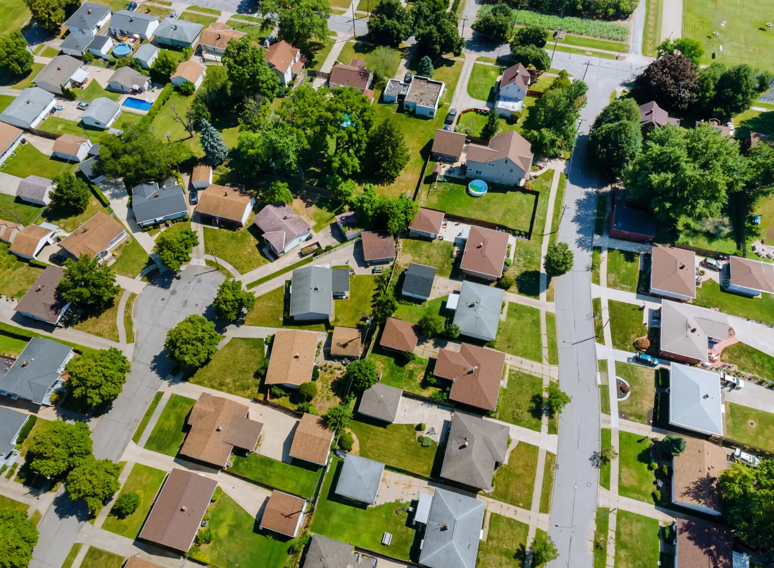 Aerial view of residential neighborhood rooftops showing diverse roof conditions for professional inspection services